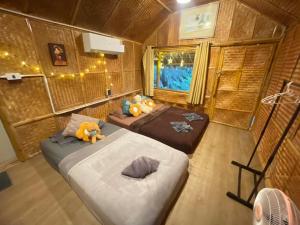 a small room with two beds and a window at Amornkeeree Khao Sok Camping in Khao Sok