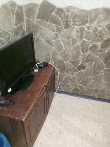 un televisor sentado en una mesa junto a una pared de piedra en Хостел AUTOMAX, en Dnipro