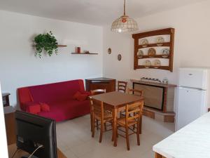a living room with a red couch and a table at La Magnolia sul Lago in Campolattaro