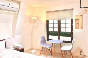 a bedroom with a bed and a table and two chairs at R Inn 新井薬師前 in Tokyo