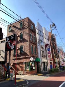 a brick building on the corner of a street at R Inn 新井薬師前 in Tokyo