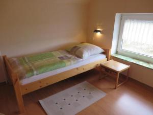 a small bedroom with a bed and a window at NEU! Ferienwohnung direkt am Deich in Neßmersiel