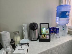 a counter with a coffee maker and other items on it at White Garden Hotel in Maputo