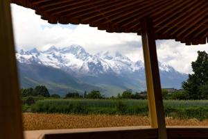 a view of a snow covered mountain from a window at LiJiang Mountain Spring Resort in Baisha +187 photos