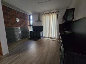 a living room with a wooden floor and a large window at Cozy Haven in Curepipe