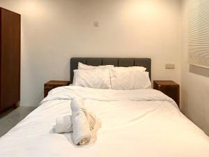 a bed with white sheets and pillows on it at Chic Designer Bedroom in Shared Bungalow near LRT SS1 PJ in Petaling Jaya