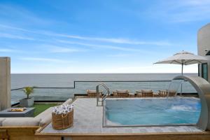ein Swimmingpool mit Blick auf das Meer in der Unterkunft Malibu Sand Carbon Beach Suites in Malibu