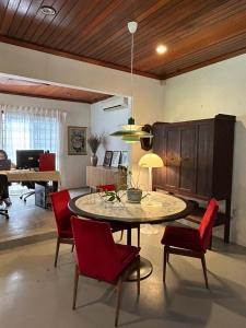 a living room with a table and red chairs at Chic Designer Bedroom in Shared Bungalow near LRT SS1 PJ in Petaling Jaya