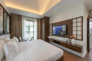a bedroom with a large bed and a tv at Green Villas Phú Quốc in Phu Quoc +61 photos