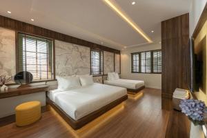 a bedroom with a bed and a couch and a television at Green Villas Phú Quốc in Phu Quoc