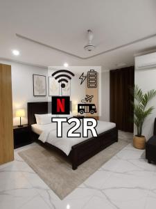2-Bedroom Apartment near Islamabad International Airport Free Airport Pick and Drop في اسلام اباد: غرفة نوم بها سرير مكتوب عليه كلمة tar