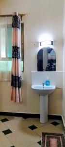 un baño con lavabo y espejo en Shanzu Gem, en Mombasa