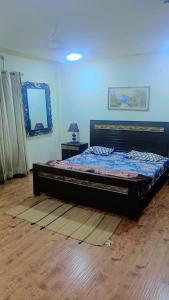 a bedroom with a bed and a blue wall at Furnished apartments in Rawalpindi