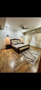 a bedroom with a bed and a rug on the floor at Furnished apartments in Rawalpindi