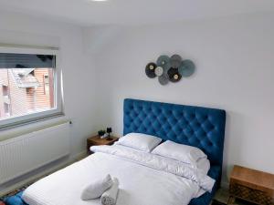a bed with a blue headboard in a bedroom at Villa Aspen Brezovica Kosovo in Brezovicë