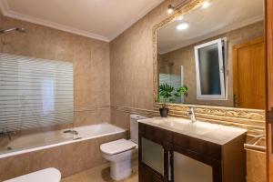 a bathroom with a tub and a toilet and a sink at Spacious villa for 10 with private pool in El Port +16 photos