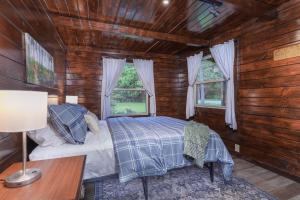 a bedroom with a bed and a desk and windows at Little Redwood - Hocking Hills, Hot Tub & Games in Logan