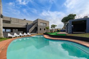 a swimming pool with chairs in front of a building at Ya Rona Sea View -5 Bedroom Ramsgate Holiday Home KRB1 in Margate