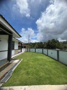a large backyard with a fence and grass at CornerNest Bertam Homestay in Kepala Batas