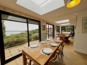 Un comedor con una mesa y un gran ventanal. en Ker Su e- maison familial, en Carantec