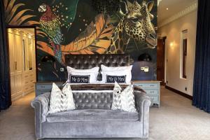 a living room with a couch and a giraffe mural at Franschhoek Homestead Manor House in Franschhoek