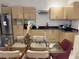 a small kitchen with a glass table and chairs at Kalinou Niamey in Niamey