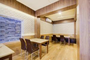 a conference room with tables and chairs and a brick wall at Townhouse OAK Seventy Seven in Dum Dum