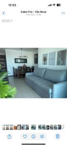 Una sala de estar con un sofá y un comedor. en Apartamento Azul Turquesa Praia do Forte Tudo a Pé, en Cabo Frío