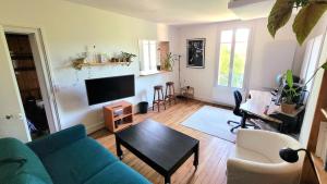 a living room with a blue couch and a table at Charming apartment bordering Versailles in Buc
