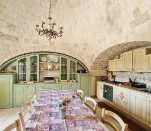 a kitchen with a long table in a room at Trulli Pax Animi in Martina Franca
