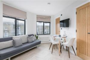 a living room with a couch and a table at Luxe 2 bed - 20 minutes from Central London in London