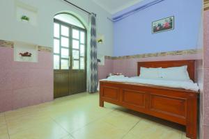 a bedroom with a bed and a large window at Minh Hồng Hotel in Ho Chi Minh City