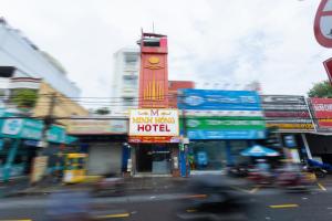 a busy city street with a building with a clock tower at Minh Hồng Hotel in Ho Chi Minh City