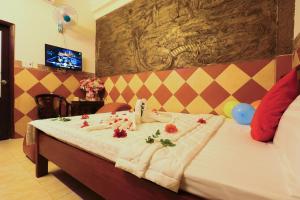 a bedroom with a bed with flowers on it at Minh Hồng Hotel in Ho Chi Minh City +14 photos