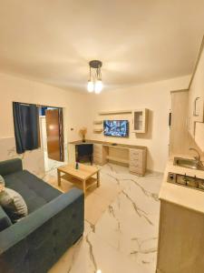 a living room with a blue couch and a kitchen at Ammoun Luxury Apartments 1 in Amman