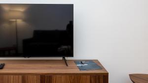 TV de pantalla plana en la parte superior de un centro de entretenimiento de madera en Testaccio's Heart by Rentbeat, en Roma