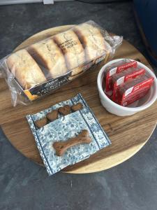 a wooden table with bread and a plate of food at Chy An Lur in Redruth