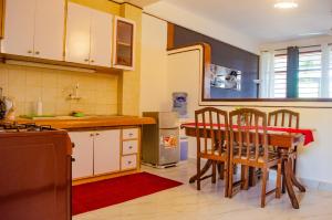 a kitchen with a table and chairs in it at Bright Diani Studio with King Bed, 2min to Beach in Diani Beach