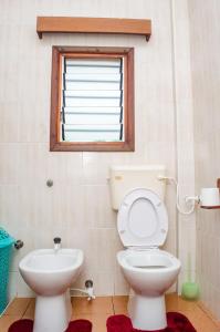 ein Badezimmer mit Toilette und Fenster in der Unterkunft Bright Diani Studio with King Bed, 2min to Beach in Diani Beach + 9 Fotos
