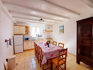 a kitchen with a table with chairs and a refrigerator at Kerantum à10mn des baies de Douarnenez et Audierne avec cuisine à disposition in Mahalon