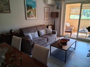 a living room with a couch and a table at Domaine du Préconil in Sainte-Maxime +2 photos