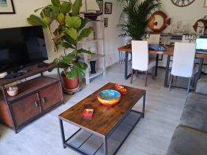 a living room with a table and a tv at Domaine du Préconil in Sainte-Maxime