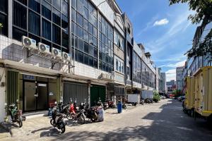 a row of motorcycles parked in front of a building at JJ House Mitra RedDoorz in Jakarta