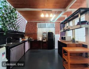a kitchen with black counters and a refrigerator at Friend Nest Bangkok in Bangkok