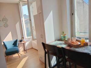 een eetkamer met een tafel en een blauwe stoel bij Les Apparts de Marmande - Petit Cocon en ville in Marmande +5 foto's