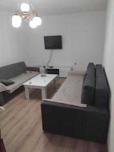 a living room with a black couch and a tv at Nadica Apartment in Struga
