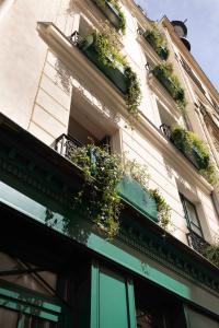 a building with potted plants on the side of it at Hôtel Aubépine in Paris