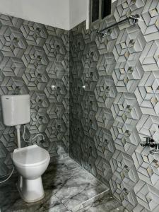 a bathroom with a toilet and a stone wall at The Boho House in Darbhanga +2 photos
