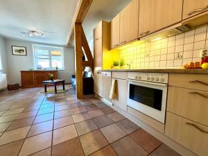 a kitchen with a stove top oven next to a table at FERIENWOHNUNGEN Krull App 02 in Ahrenshoop