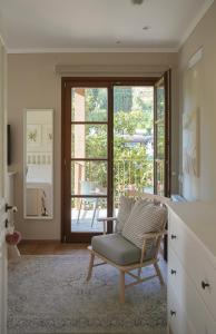 a living room with a chair and a sliding glass door at Stou Savvide - Pera Pedi Stone Manor in Perapedhi